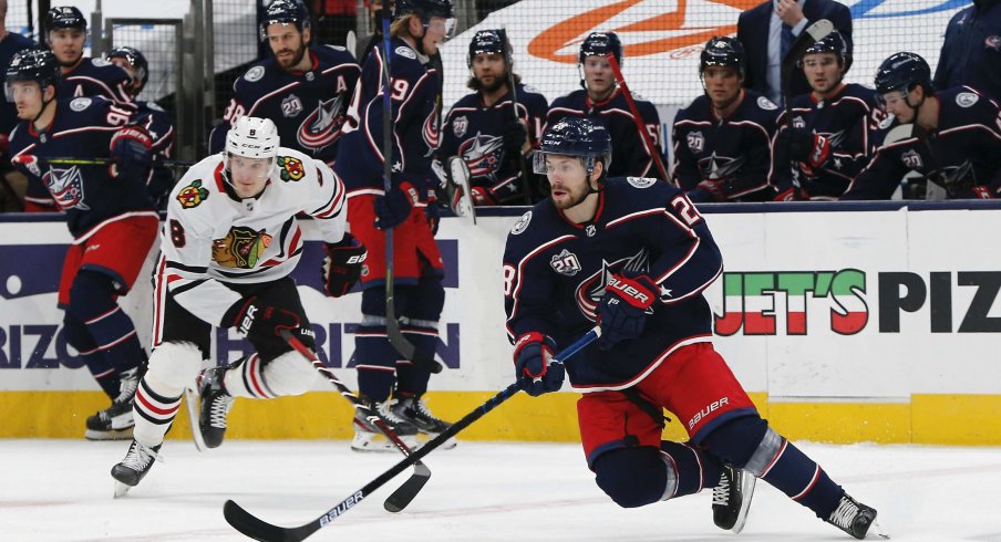 Feb 25, 2021; Columbus, Ohio, USA; Columbus Blue Jackets right wing Oliver Bjorkstrand (28) grabs a loose puck against the Chicago Blackhawks during the first period at Nationwide Arena.