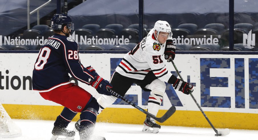 Chicago Blackhawks defenseman Ian Mitchell (51) and Columbus Blue Jackets right wing Oliver Bjorkstrand (28) chase down a loose puck during the first period at Nationwide Arena.