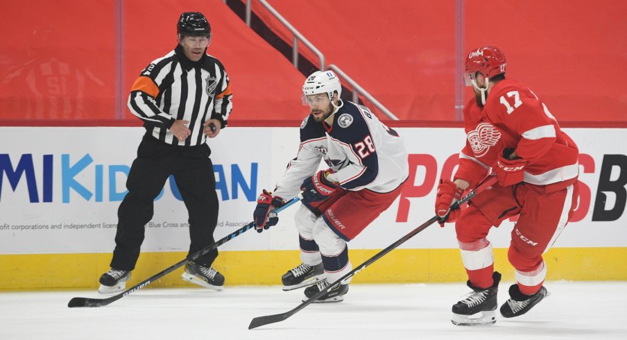 Columbus Blue Jackets right wing Oliver Bjorkstrand controls the puck as Detroit Red Wings defenseman Filip Hronek defends during the first meeting of the season between the two teams.