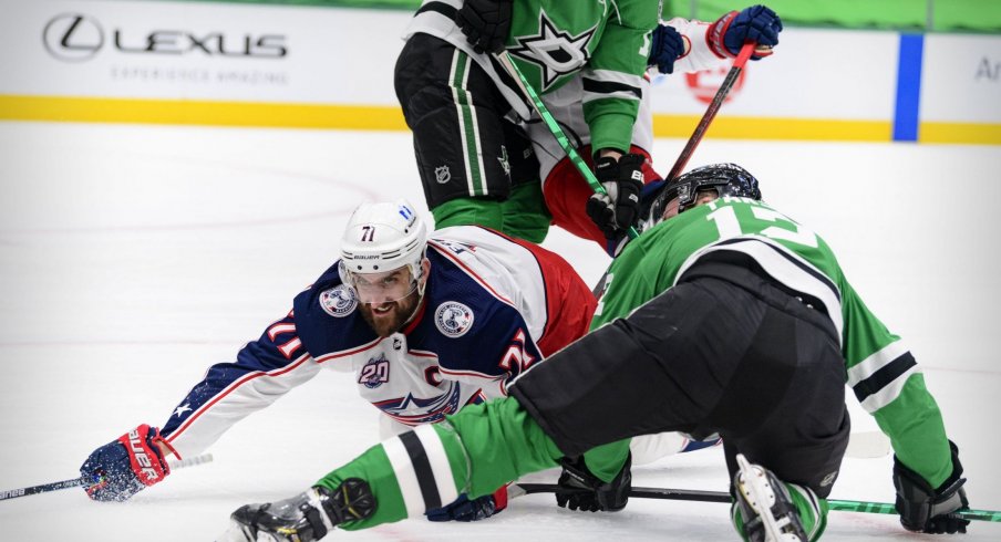 Mar 4, 2021; Dallas, Texas, USA; Columbus Blue Jackets left wing Nick Foligno (71) and Dallas Stars center Radek Faksa (12) fight for the loose puck during the first period at the American Airlines Center.