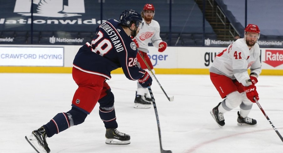 Columbus Blue Jackets right wing Oliver Bjorkstrand (28) shoots over the stick of Detroit Red Wings center Luke Glendening (41) during the third period at Nationwide Arena. 