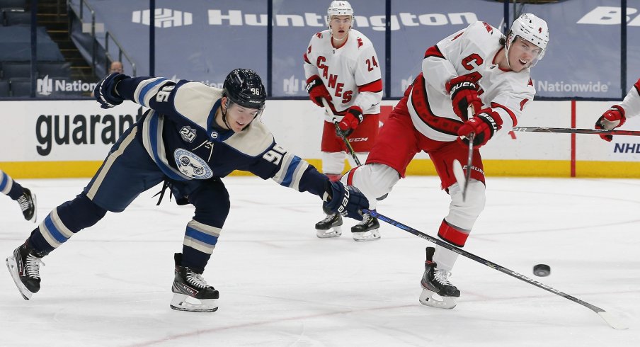 Carolina Hurricanes defenseman Haydn Fleury (4) clears the puck as Columbus Blue Jackets center Jack Roslovic (96) deflects the puck during the third period at Nationwide Arena.