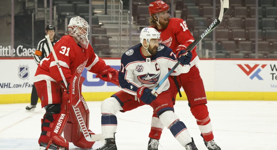 Columbus Blue Jackets left wing Nick Foligno (71) and Detroit Red Wings defenseman Marc Staal (18) fight for position with in front of goaltender Calvin Pickard (31) in the first period at Little Caesars Arena.