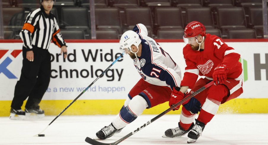Mar 27, 2021; Detroit, Michigan, USA; Columbus Blue Jackets left wing Nick Foligno (71) skates with the puck defended by Detroit Red Wings defenseman Filip Hronek (17) in the third period at Little Caesars Arena.