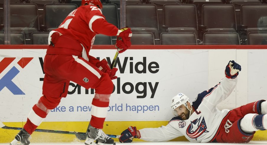 Jon Merrill and Nick Foligno battle for the puck