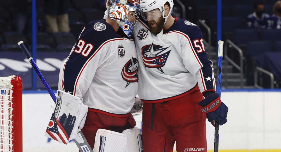 Mar 30, 2021; Tampa, Florida, USA; Columbus Blue Jackets goaltender Elvis Merzlikins (90) and defenseman David Savard (58) celebrate after defeating the Tampa Bay Lightning at Amalie Arena.