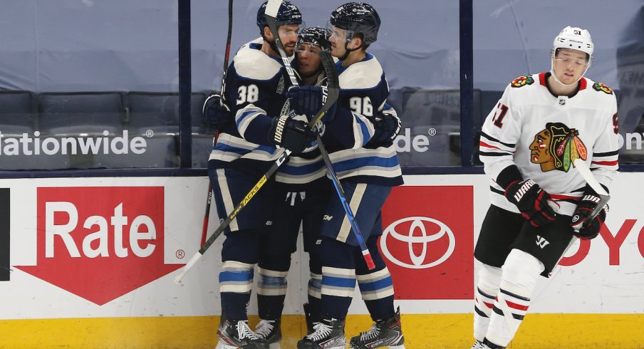 Columbus Blue Jackets forwards Jack Roslovic, Cam Atkinson, and Boone Jenner celebrate a goal scored against the Chicago Blackhawks at Nationwide Arena.