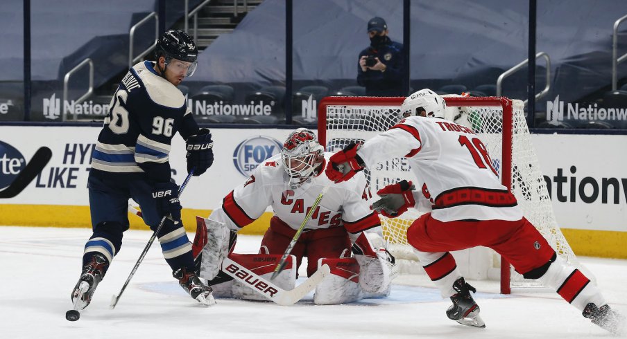 Columbus Blue Jackets forward Jack Roslovic fights for the pick against Carolina Hurricanes forward Vincent Trocheck during a game at Nationwide Arena.