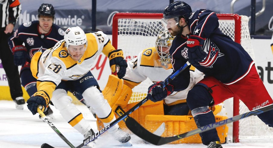 May 5, 2021; Columbus, Ohio, USA; Columbus Blue Jackets right wing Oliver Bjorkstrand (28) passes the puck as Nashville Predators right wing Eeli Tolvanen (28) reaches for the steal during the first period at Nationwide Arena.