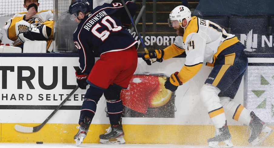 May 5, 2021; Columbus, Ohio, USA; Columbus Blue Jackets left wing Eric Robinson (50) and Nashville Predators defenseman Mattias Ekholm (14) battle for the puck during the first period at Nationwide Arena.