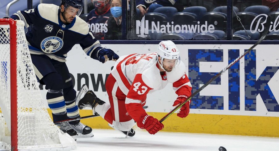 May 7, 2021; Columbus, Ohio, USA; Columbus Blue Jackets defenseman Michael Del Zotto (15) skates against Detroit Red Wings left wing Darren Helm (43) for the loose puck in the second period at Nationwide Arena.