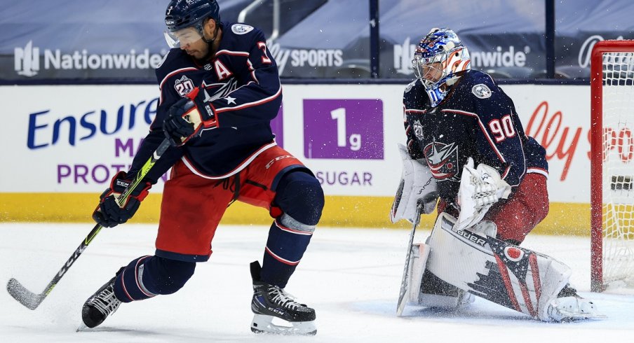 Seth Jones (3) reacts as goaltender Elvis Merzlikins makes a save in net against the Detroit Red Wings