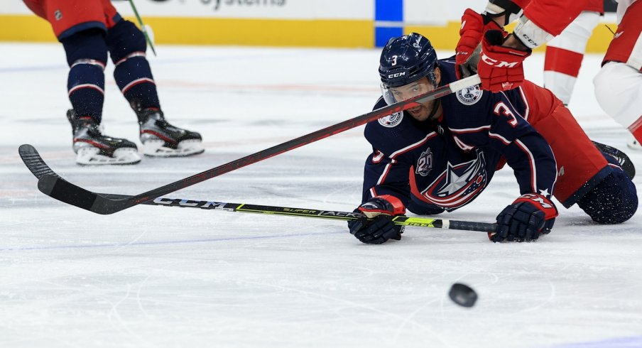 Columbus Blue Jackets defenseman Seth Jones (3) passes the puck as he falls to the ice against Detroit Red Wings center Luke Glendening (41) in the third period at Nationwide Arena.