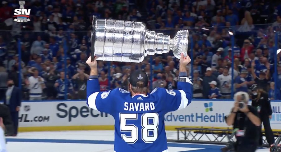 David Savard lifts the Stanley Cup above his shoulders.