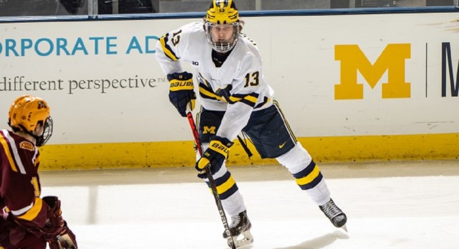 Kent Johnson skates with the puck against the University of Minnesota