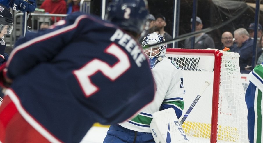 Vancouver Canucks goaltender Louis Domingue (30) makes a save on a shot by Columbus Blue Jackets defenseman Andrew Peeke (2) in the second period at Nationwide Arena.