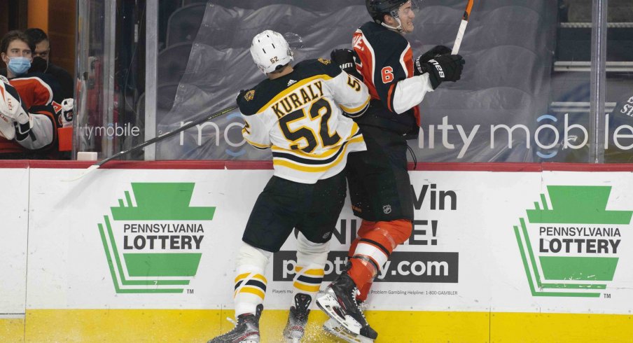 Apr 10, 2021; Philadelphia, Pennsylvania, USA; Boston Bruins center Sean Kuraly (52) checks Philadelphia Flyers defenseman Travis Sanheim (6) into the boards in the first period at the Wells Fargo Center.