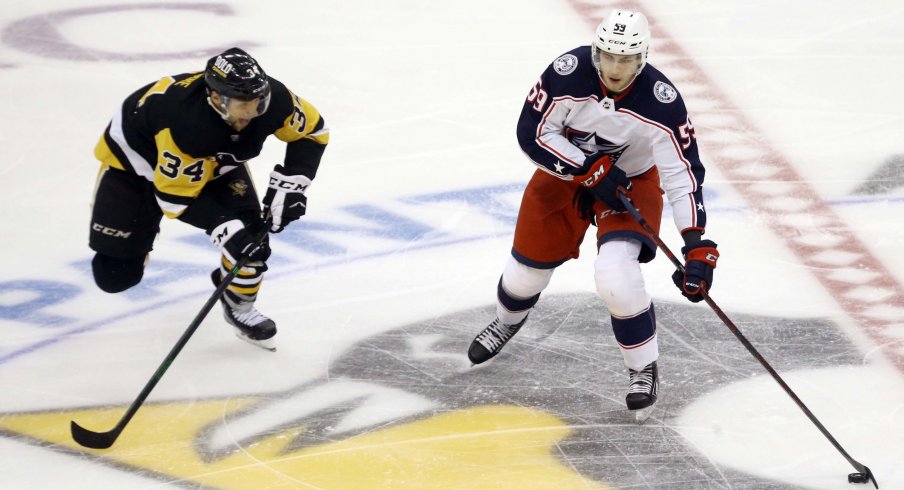 Sep 27, 2021; Pittsburgh, Pennsylvania, USA; Columbus Blue Jackets forward Yegor Chinakhov (59) moves the puck against Pittsburgh Penguins forward Nathan Legare (34) during the third period at PPG Paints Arena. The Blue Jackets won 3-0.