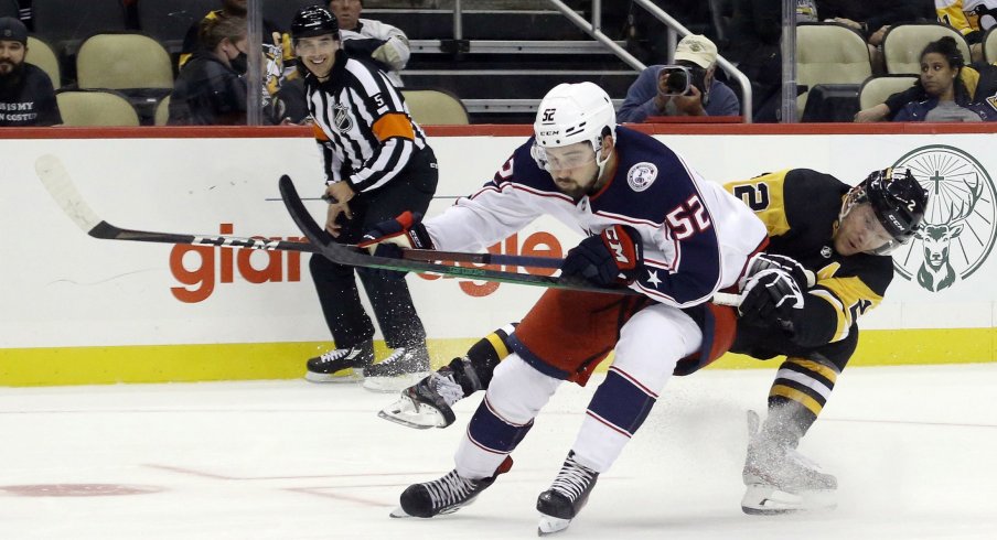 Sep 27, 2021; Pittsburgh, Pennsylvania, USA; Columbus Blue Jackets center Emil Bemstrom (52) skates with the puck around Pittsburgh Penguins defenseman Chad Ruhwedel (2) during the second period at PPG Paints Arena.