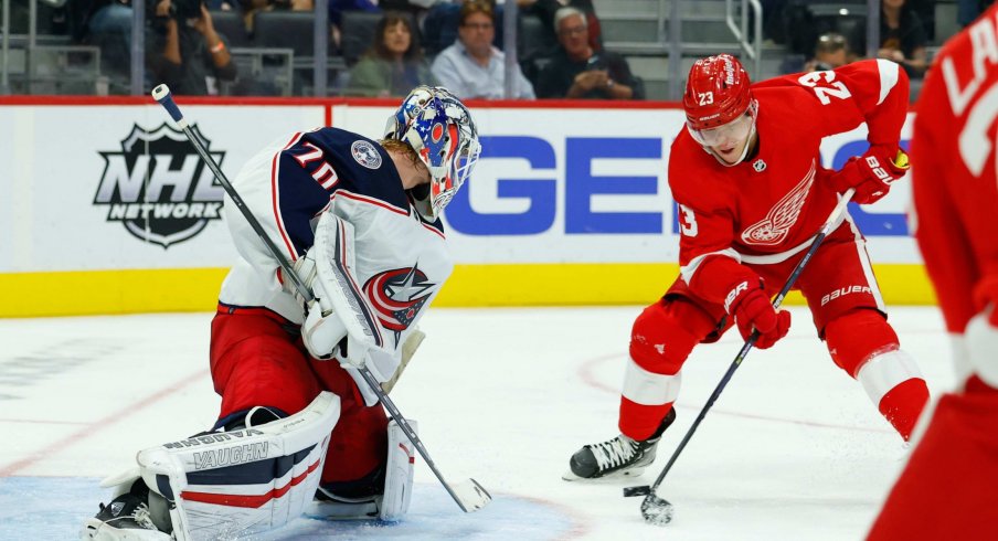 Oct 19, 2021; Detroit, Michigan, USA; Detroit Red Wings right wing Lucas Raymond (23) tries to score on Columbus Blue Jackets goaltender Joonas Korpisalo (70) in the second period at Little Caesars Arena. 