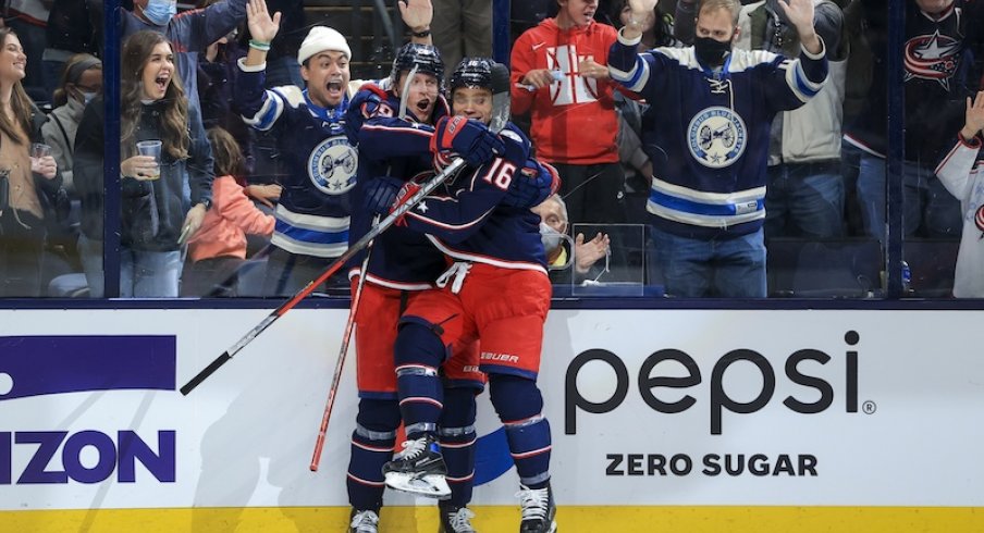 Columbus Blue Jackets forwards Patrik Laine and Max Domi celebrating a goal at Nationwide Arena.
