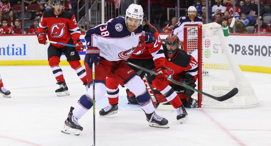 Oct 31, 2021; Newark, New Jersey, USA; Columbus Blue Jackets center Boone Jenner (38) plays the puck while being defended by New Jersey Devils defenseman Ty Smith (24) during the first period at Prudential Center.