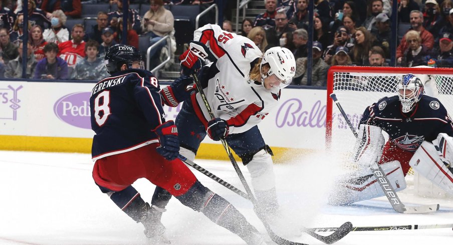 Nov 12, 2021; Columbus, Ohio, USA; Columbus Blue Jackets defenseman Zach Werenski (8) sticks a rebound away from Washington Capitals left wing Axel Johnson-Fjallby (45) during the second period at Nationwide Arena