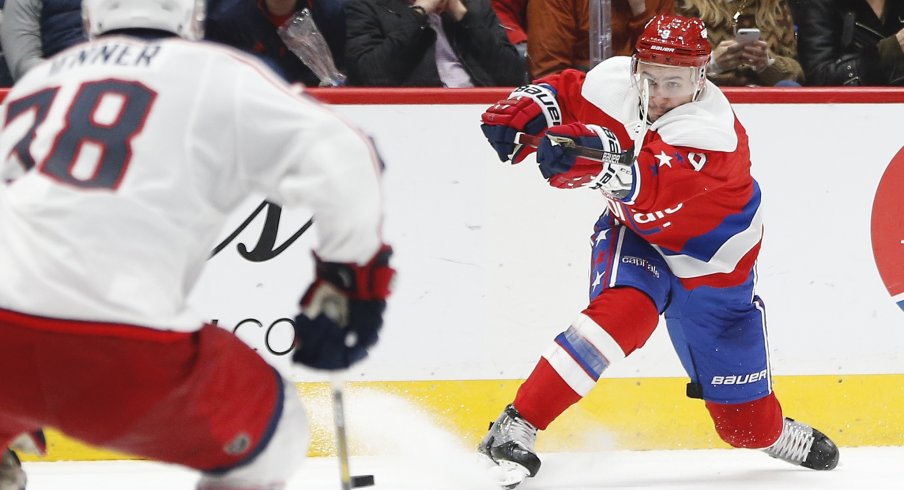 Dec 9, 2019; Washington, DC, USA; Washington Capitals defenseman Dmitry Orlov (9) shoots the puck as Columbus Blue Jackets center Boone Jenner (38) defends in the second period at Capital One Arena.