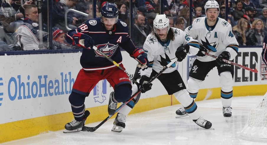 Jan 4, 2020; Columbus, Ohio, USA; Columbus Blue Jackets center Boone Jenner (38) and San Jose Sharks defenseman Erik Karlsson (65) battle for the puck during the second period at Nationwide Arena.