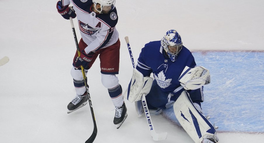 Toronto Maple Leafs goaltender Frederik Andersen (31) makes a glove save as Columbus Blue Jackets forward Boone Jenner (38) looks on during the first period of game five of the Eastern Conference qualifications at Scotiabank Arena