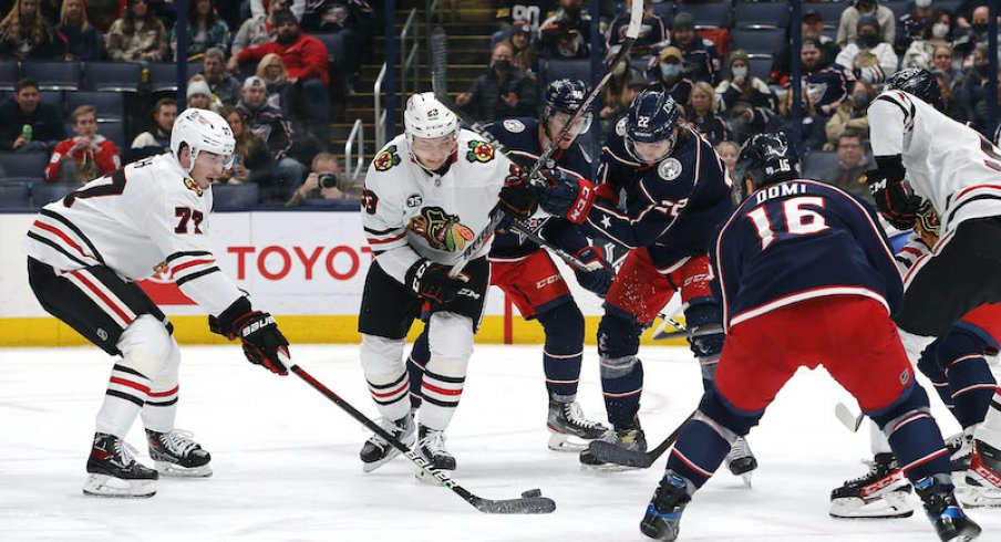 Kirby Dach of the Chicago Blackhawks battles for the loose puck against the Columbus Blue Jackets at Nationwide Arena.