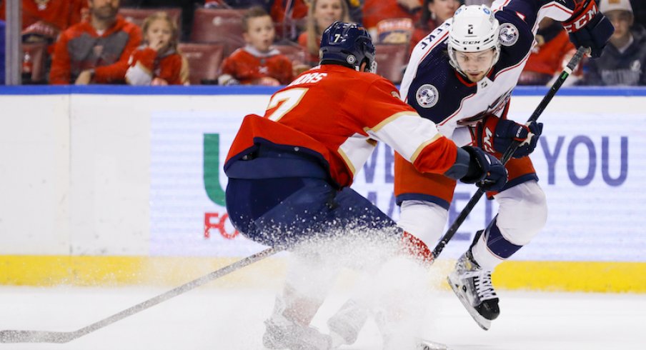 Columbus Blue Jackets defenseman Andrew Peeke skates with the puck against Florida Panthers defenseman Radko Gudas in the first period at FLA Live Arena.