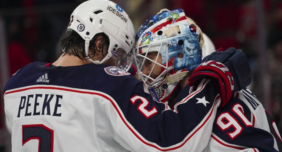 Columbus Blue Jackets' Elvis Merzlikins and Andrew Peeke celebrate a victory over the Carolina Hurricanes at PNC Arena.