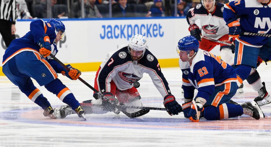New York Islanders' Sebastian Aho and Casey Cizikas battle for the loose puck with Columbus Blue Jackets' Sean Kuraly in the first period at UBS Arena.
