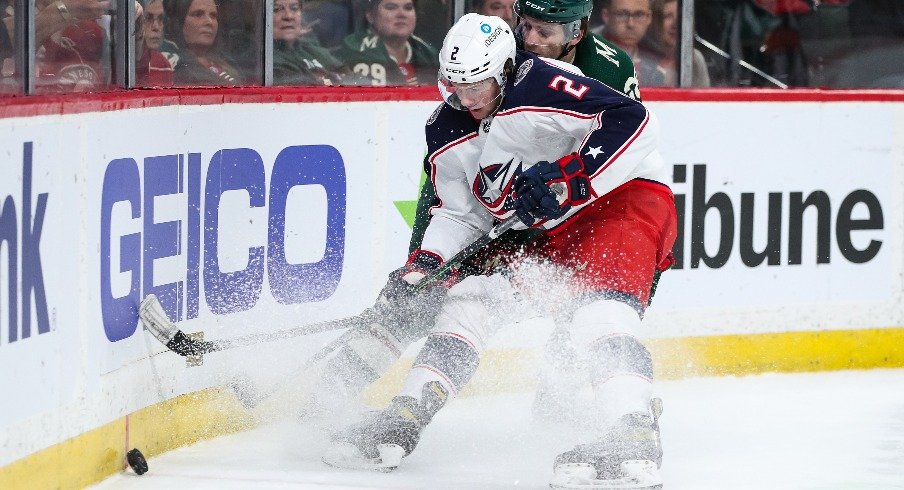 Mar 26, 2022; Saint Paul, Minnesota, USA; Columbus Blue Jackets defenseman Andrew Peeke (2) and Minnesota Wild right wing Ryan Hartman (38) battle for the puck in the second period at Xcel Energy Center. 