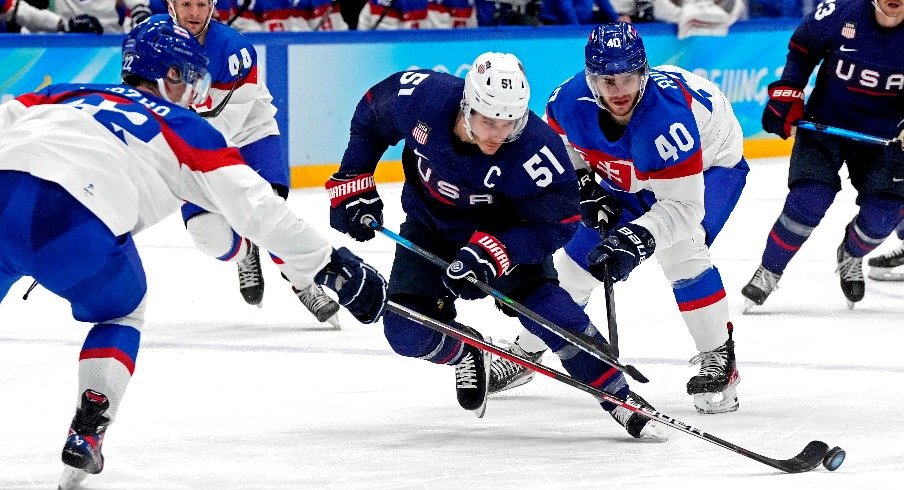 United States forward Andy Miele (51) and Slovakia defender Samuel Knazko (22) go for the puck in the men s ice hockey quarterfinal during the Beijing 2022 Olympic Winter Games