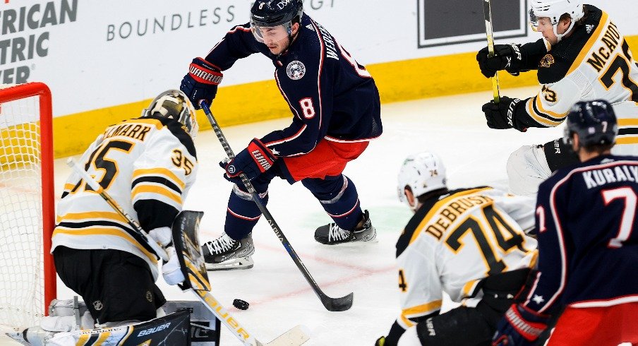 Columbus Blue Jackets defenseman Zach Werenski takes a shot ton net as he skates against Boston Bruins defenseman Charlie McAvoy in the second period at Nationwide Arena.