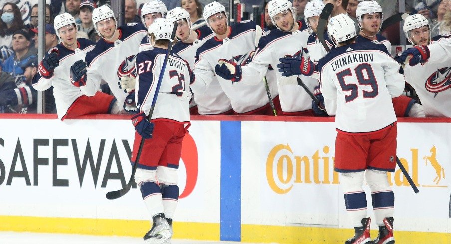 Columbus Blue Jackets defenseman Adam Boqvist (27) is congratulated by his team mates on his goal against Winnipeg Jets goalie Eric Comrie (1) during the first period at Canada Life Centre.