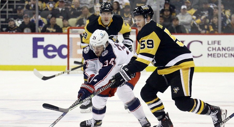 Columbus Blue Jackets center Cole Sillinger and Pittsburgh Penguins left wing Jake Guentzel chase the puck during the third period at PPG Paints Arena. The Penguins won 5-1.