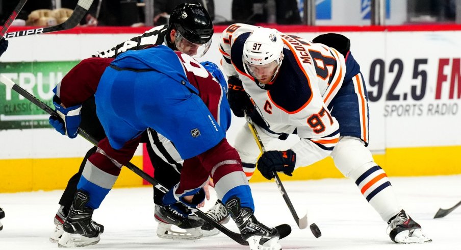 Nathan MacKinnon and Connor McDavid face off