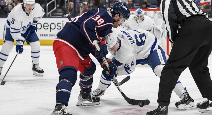 Columbus Blue Jackets center Boone Jenner and Toronto Maple Leafs center David Kampf face-off in the first period at Nationwide Arena.