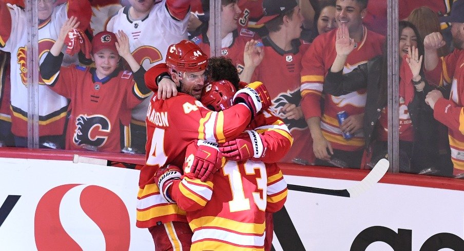 Calgary Flames defenseman Erik Gudbranson (44) forward Johnny Gaudreau (13) and forward Matthew Tkachuk celebrate the overtime win over the Dallas Stars in game seven of the first round of the 2022 NHL Playoffs.