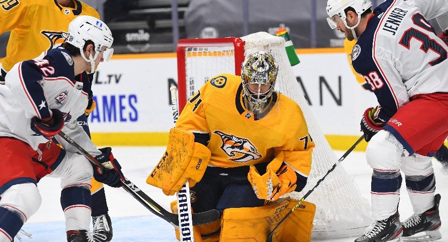 Nashville Predators goaltender Juuse Saros makes a save against traffic from Columbus Blue Jackets center Alexandre Texier and center Boone Jenner during the second period.
