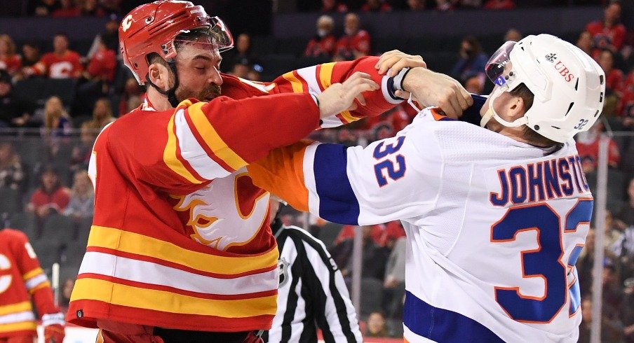 Calgary Flames defenseman Erik Gudbranson  fights with New York Islanders forward Ross Johnston during the second period at Scotiabank Saddledome.