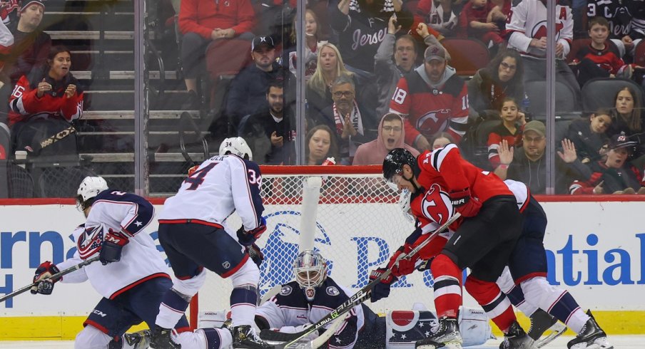 The Blue Jackets try to defend against the New Jersey Devils