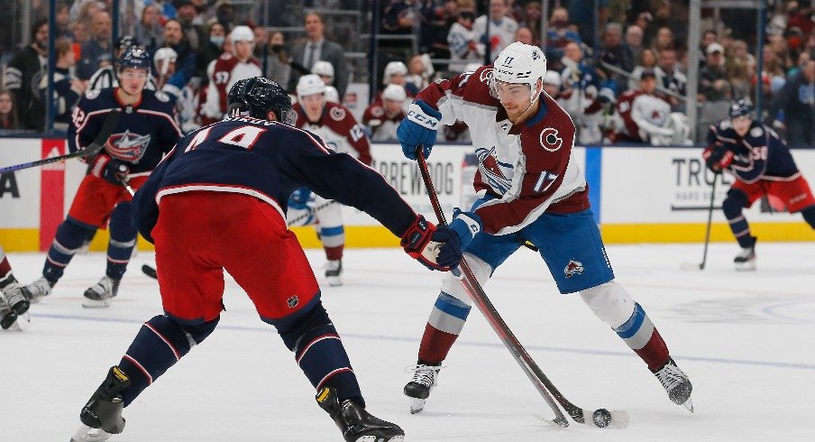 Colorado Avalanche center Tyson Jost shoots the puck against Columbus Blue Jackets defenseman Vladislav Gavrikov during the third period at Nationwide Arena.