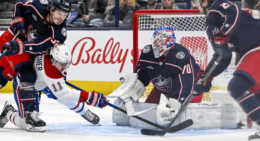 Montreal Canadiens' Brendan Gallagher shoots the puck as Columbus Blue Jackets' Cole Sillinger knocks him down in front of Columbus Blue Jackets goaltender Joonas Korpisalo (70) in the second period at Nationwide Arena.