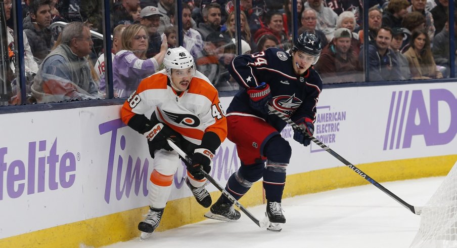 Cole Sillinger battles for control of a loose puck during the first period at Nationwide Arena