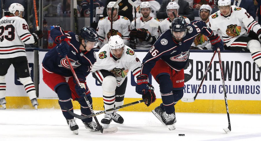 Chicago Blackhawks' Seth Jones and Columbus Blue Jackets' Kirill Marchenko chase down a loose puck during the first period at Nationwide Arena.