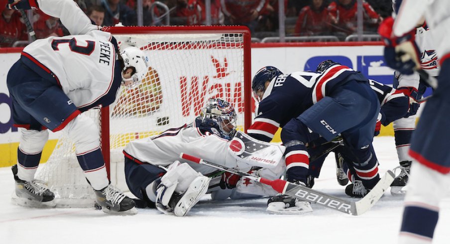 Columbus Blue Jackets' Elvis Merzlikins and Blue Jackets' Andrew Peeke make a save against Washington Capitals defenseman Martin Fehervary during the first period at Capital One Arena.